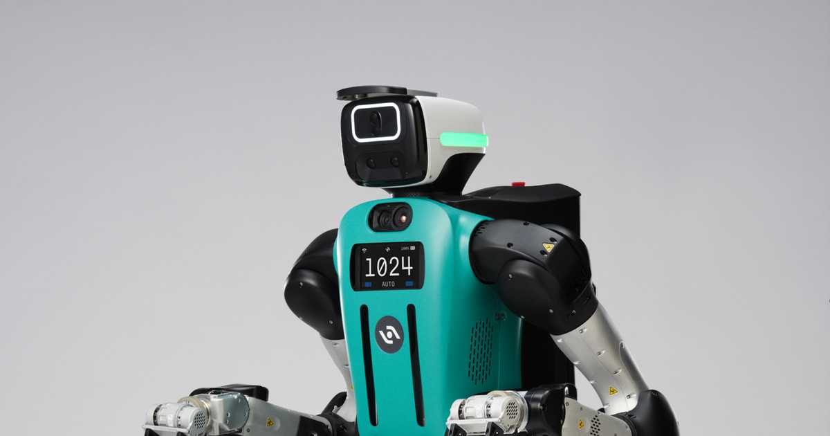 Digit 5 humanoid robot, teal and black, standing against a grey studio background