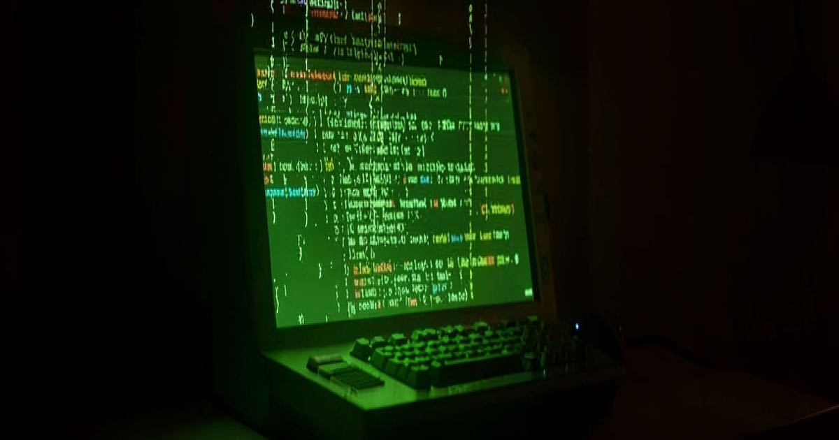 An abstract digital scene showing a glowing green computer terminal with cascading code in a darkened room with warm amber light