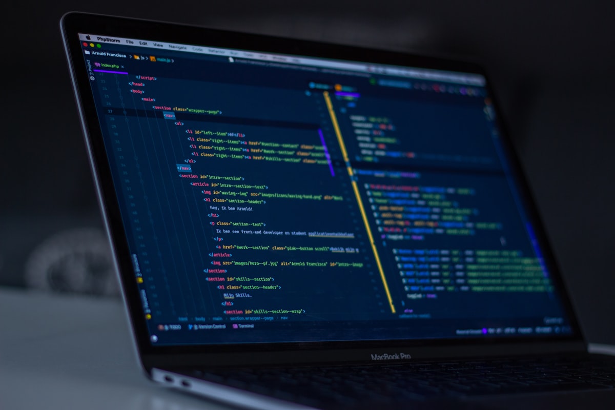 A developer's desk with three monitors showing code review tools and a warm desk lamp, muted colours, contemplative atmosphere, documentary style photography