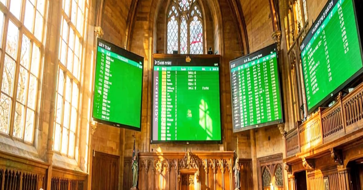 A bright sunlit NZ Parliament chamber with voting screens showing unanimous green ticks, symbolising cross-party support for the deepfake bill.